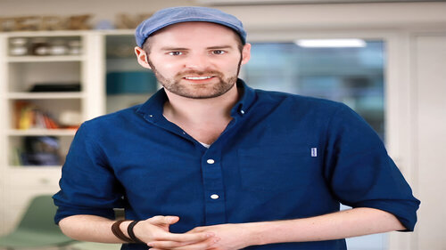 Porträtfoto von Julian van Dieken, lächelnd in einem Büro stehend