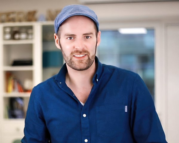 Porträtfoto von Julian van Dieken, lächelnd in einem Büro stehend