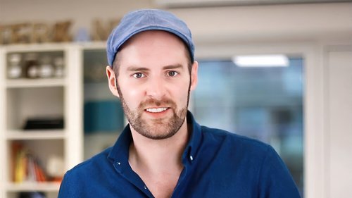 Porträtfoto von Julian van Dieken, lächelnd in einem Büro stehend