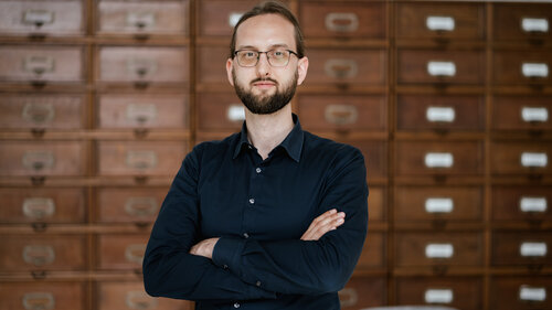 Foto von Dominik Schürmann, im Hintergrund Aktenschränke