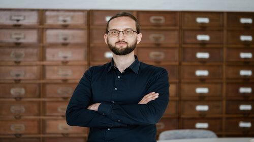 Foto von Dominik Schürmann, im Hintergrund Aktenschränke