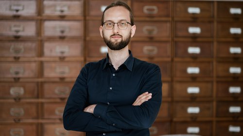 Foto von Dominik Schürmann, im Hintergrund Aktenschränke