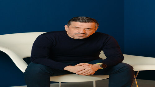 Raphael Gielgen, sitzend in einem weißen Stuhl vor einem dunkelblauen Hintergrund.