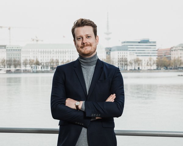 Colin Hauer, CEO von Hörbuch Hamburg steht am Alster-Ufer