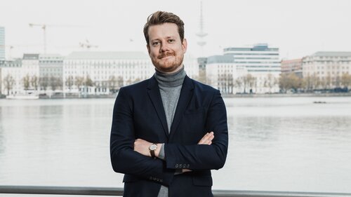 Colin Hauer, CEO von Hörbuch Hamburg steht am Alster-Ufer